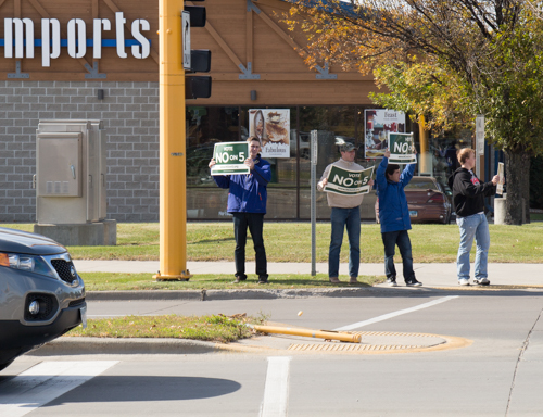 A volunteer holds a Vote No on 5 sign on a Grand Forks street corner