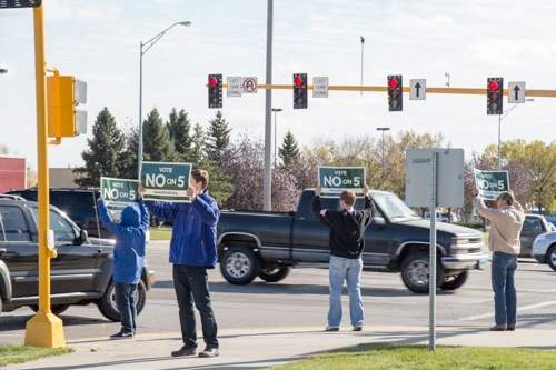 Volunteers waving Vote No on 5 signs at a Grand Forks intersection
