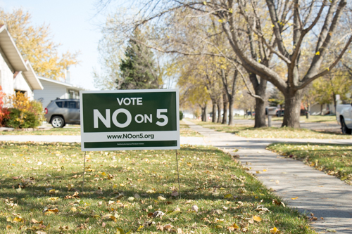A Vote No on 5 yard sign on a North Dakota lawn in fall