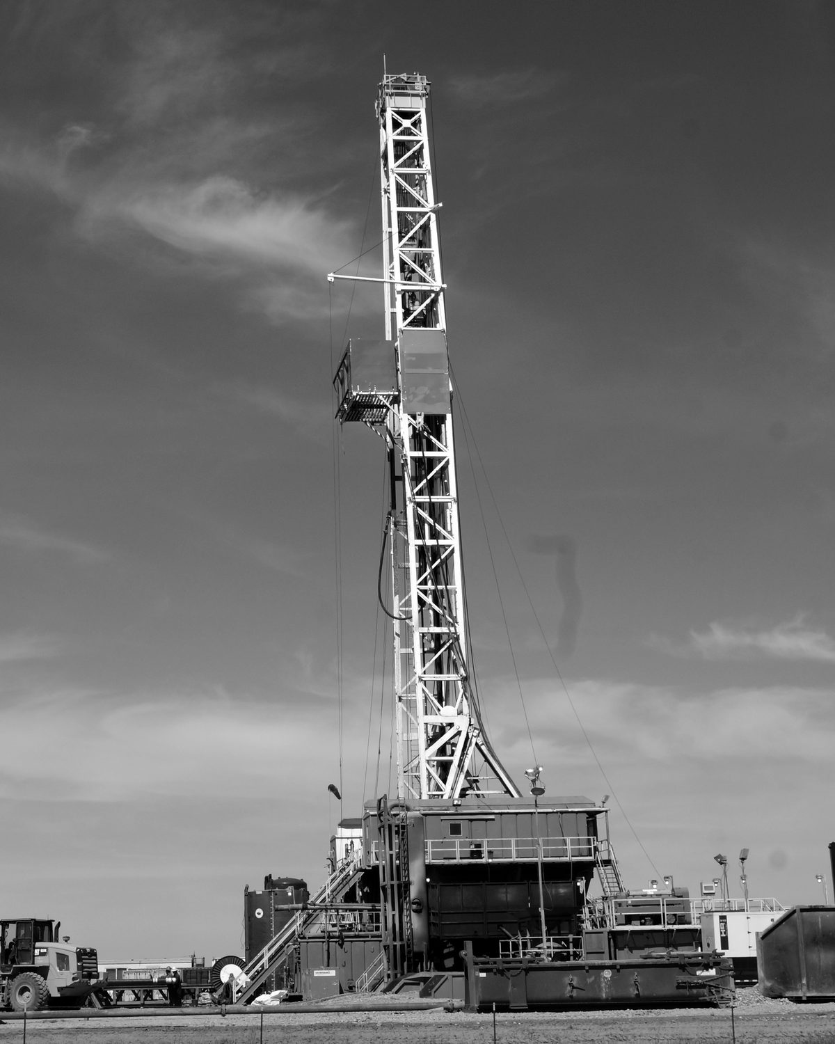 Drilling rig against the sky, in black and white
